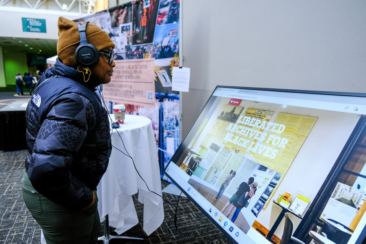 A person watching a video display with headphones.