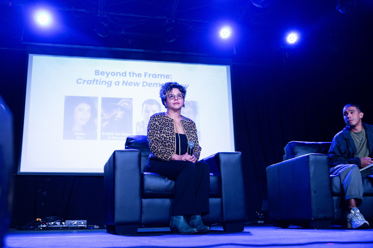 Favianna Rodriguez sitting on the main stage.