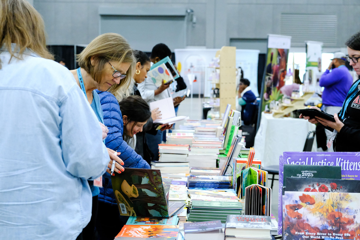 People looking through books on a vendor table.