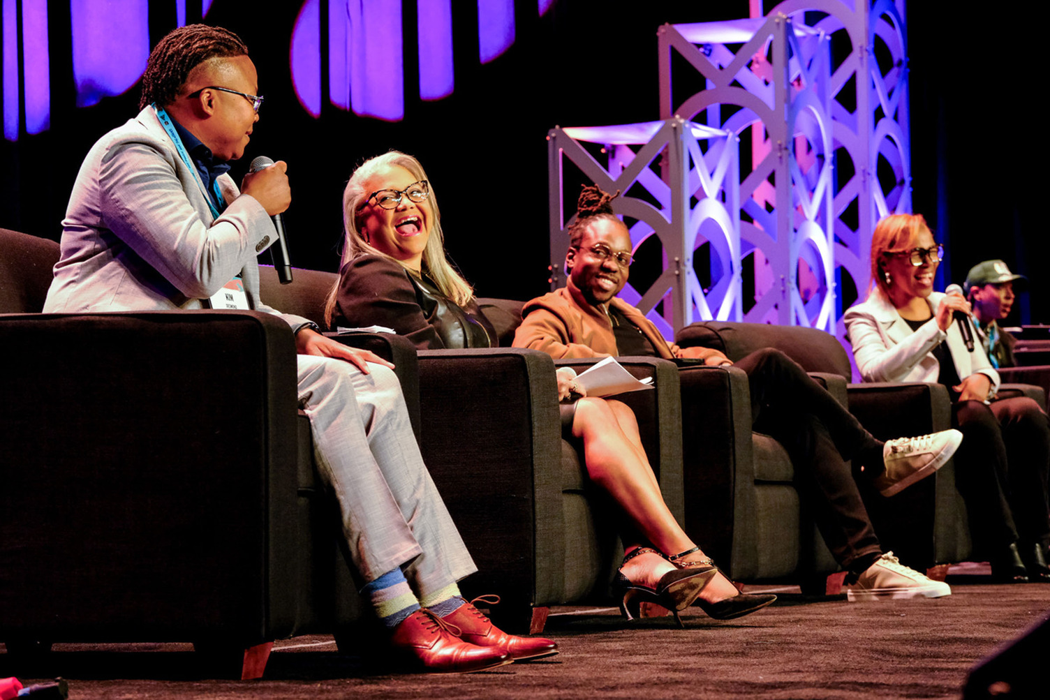 Panelists speaking on stage.