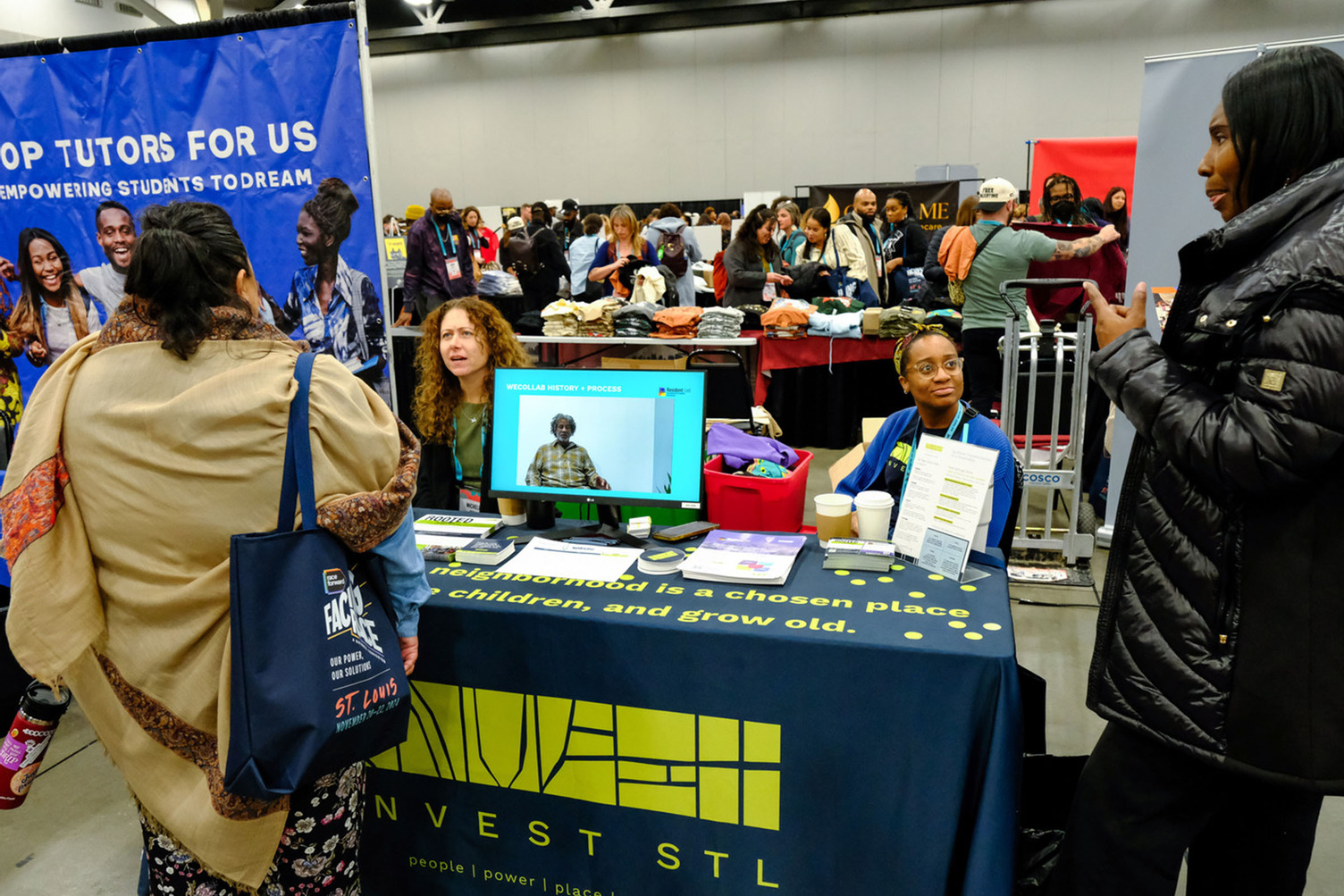 People talking to vendors at a table.