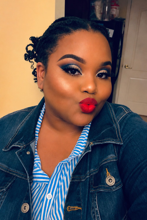 Person with lips puckered wearing blue, denim jacket.