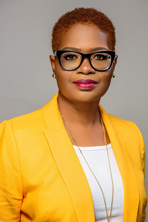Person with black glasses wearing a yellow jacket.