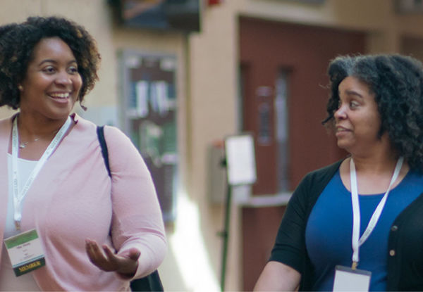 Two people walking and talking together.