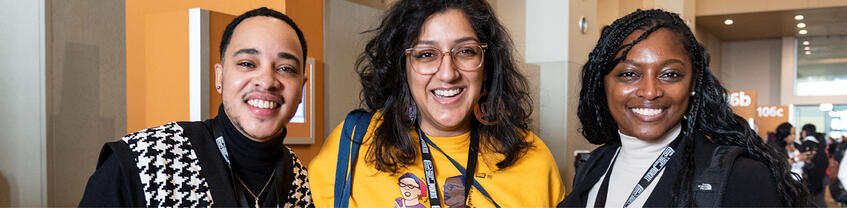 Three people looking into camera and smiling.