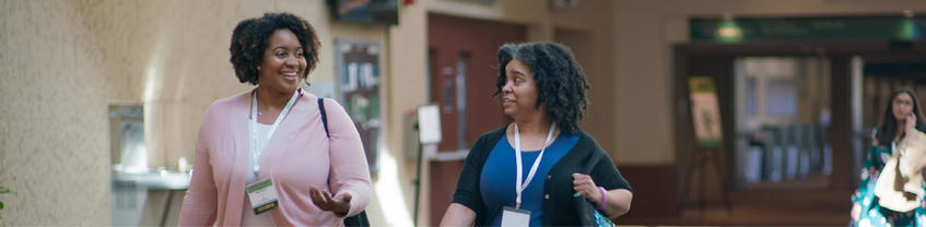 Two people walking and talking together.