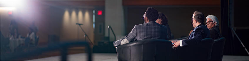 People in suits sitting in comfortable chairs.