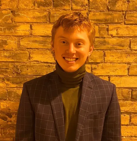 Jared Everson in brown jacket and turtleneck.