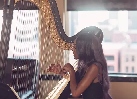 Ahya Simone playing a harp.