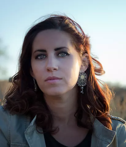Headshot of Erika Cohn looking towards camera in outdoor setting.