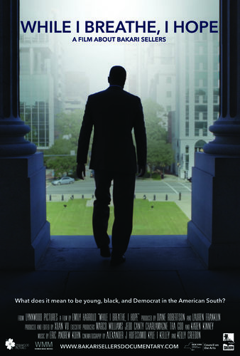While I Breathe, I Hope poster with tagline “A Film About Bakari Sellers.” Person in suit walks down steps of building toward large lawn in city with tall buildings.